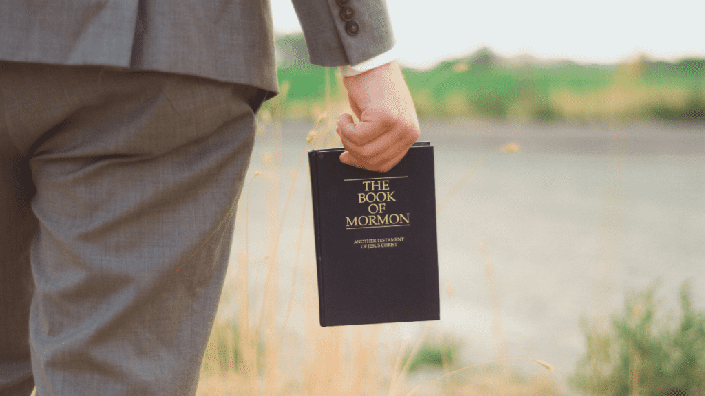 beliefs man holding book of mormon
