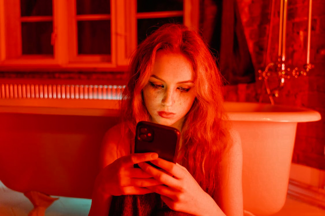 a woman with smudge on face holding a phone
