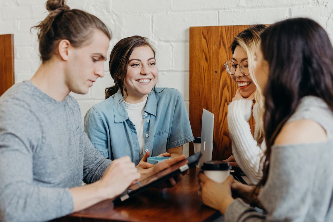 a group of people sitting around a table and talking.