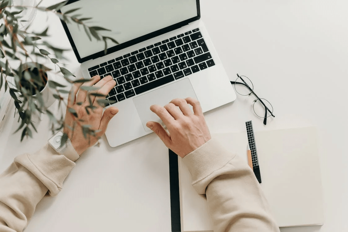 person in beige long sleeve shirt using MacBook pro