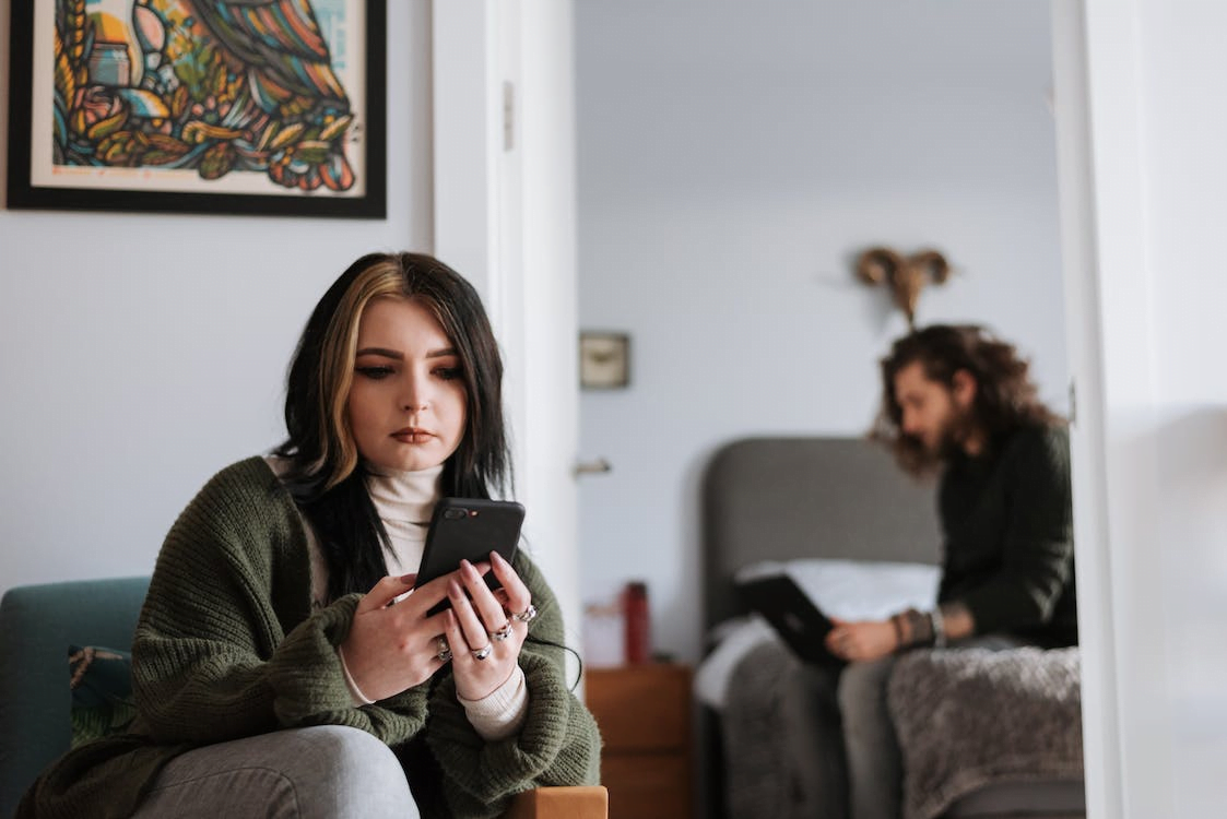 young couple using gadgets during weekend at home
