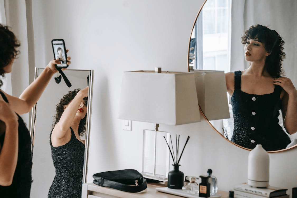 a woman wearing black taking selfie in room
