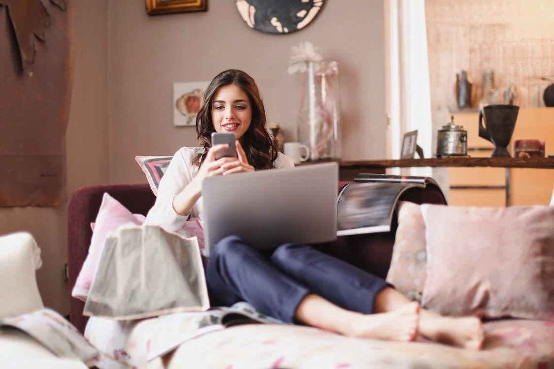 a woman using smartphone while lying on couch