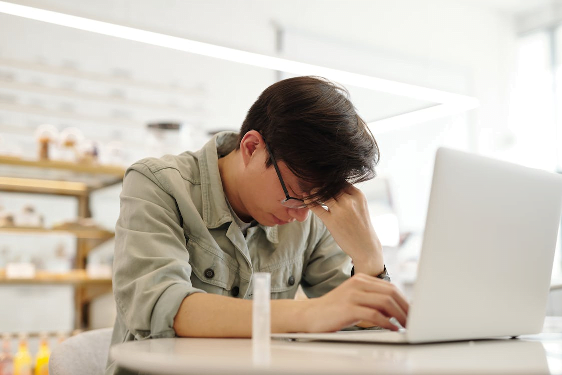 a man looking sick while working with his laptop
