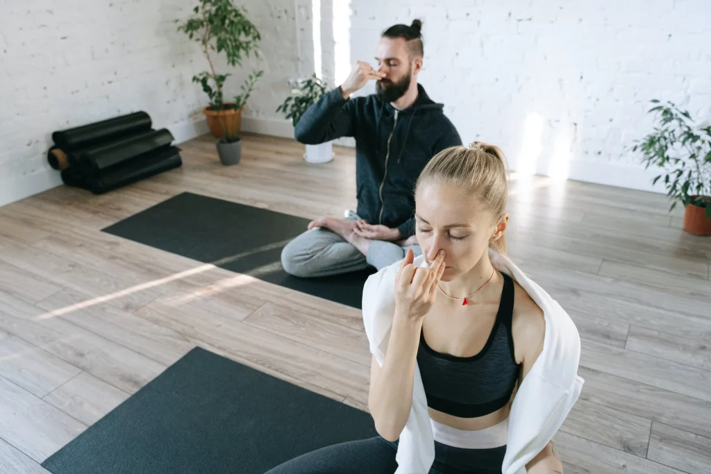 a man and a woman breathing exercise in meditation