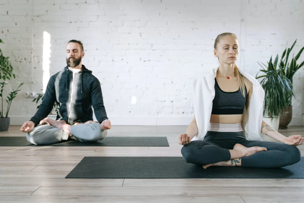 a man and a woman in lotus position meditating