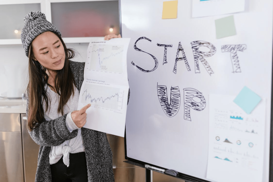 woman holding white paper with graphs