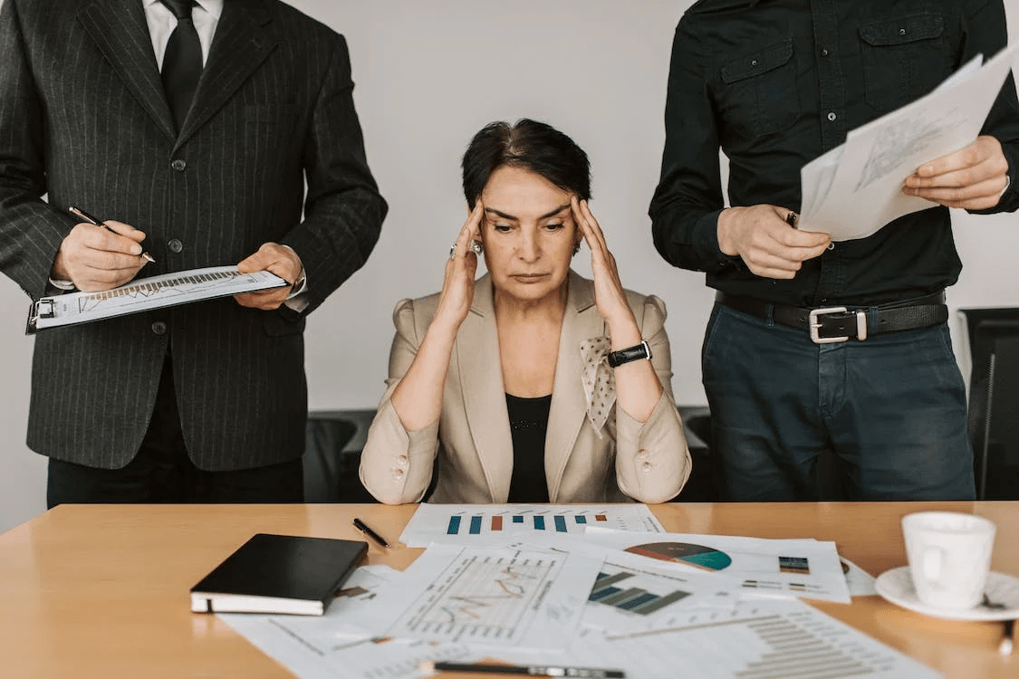 stressed elderly woman holding her head